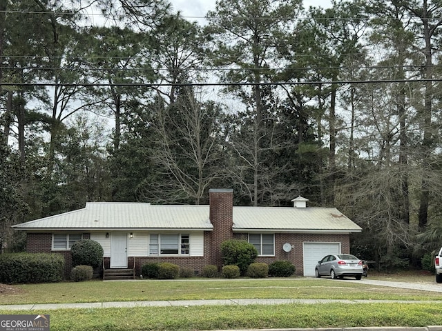 single story home featuring a garage and a front lawn