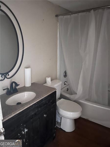 full bathroom with wood-type flooring, vanity, toilet, and shower / bathtub combination with curtain