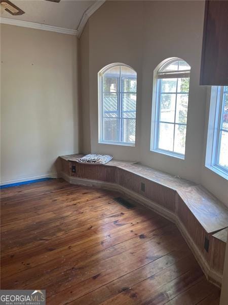 interior space featuring ceiling fan, dark hardwood / wood-style floors, ornamental molding, and a wealth of natural light