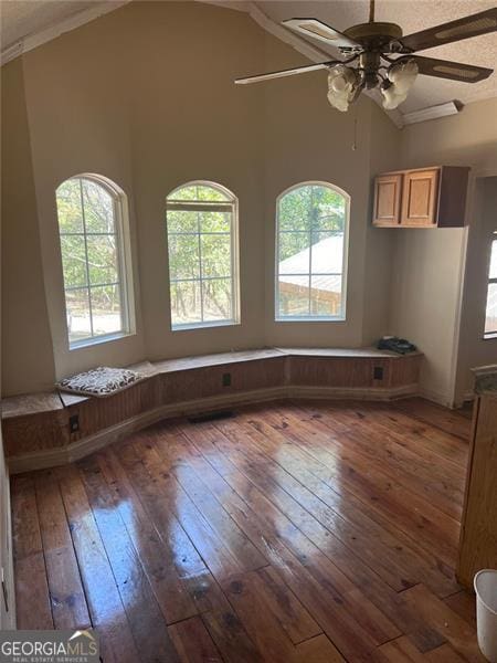 empty room featuring ceiling fan, lofted ceiling, dark hardwood / wood-style floors, and crown molding