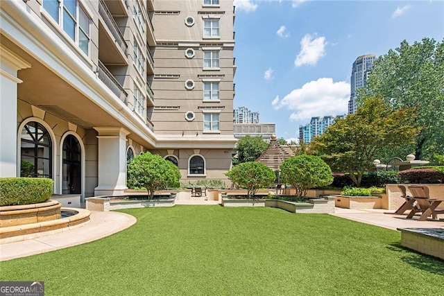 view of community featuring a patio area and a lawn