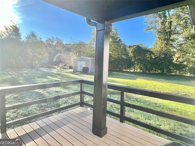 wooden deck featuring a storage shed and a lawn