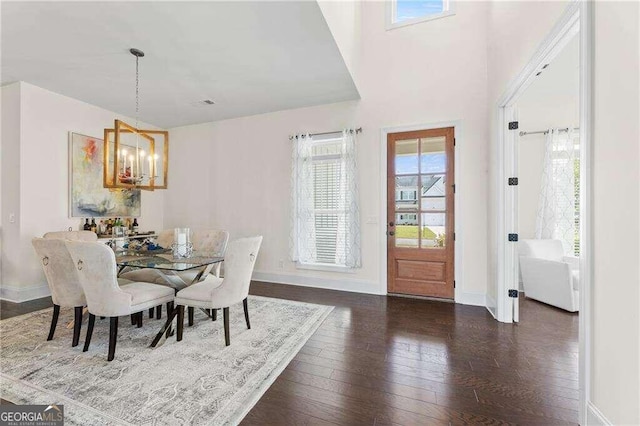 dining area with an inviting chandelier and dark hardwood / wood-style floors