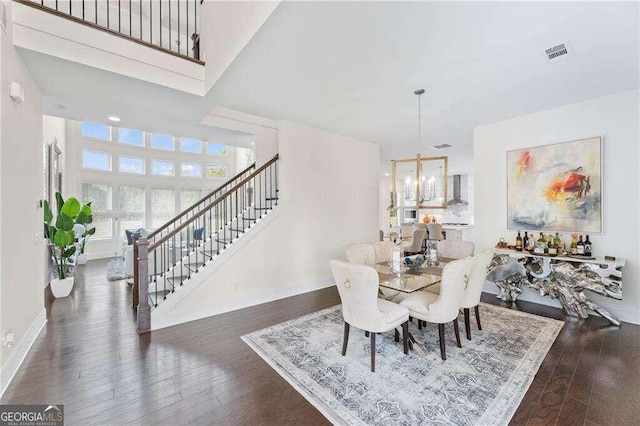 dining area featuring a chandelier, a high ceiling, and dark hardwood / wood-style flooring