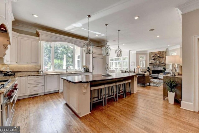 kitchen with white cabinets, light wood-type flooring, and a healthy amount of sunlight