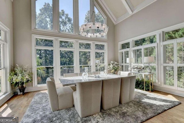 sunroom featuring beam ceiling and a notable chandelier