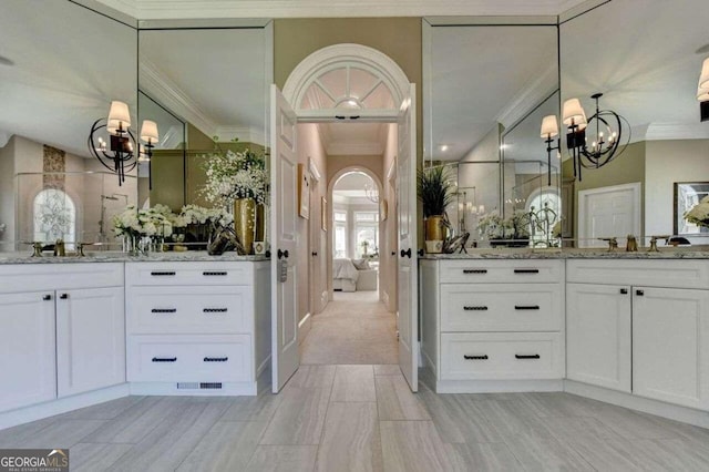 bathroom featuring a notable chandelier, crown molding, and vanity