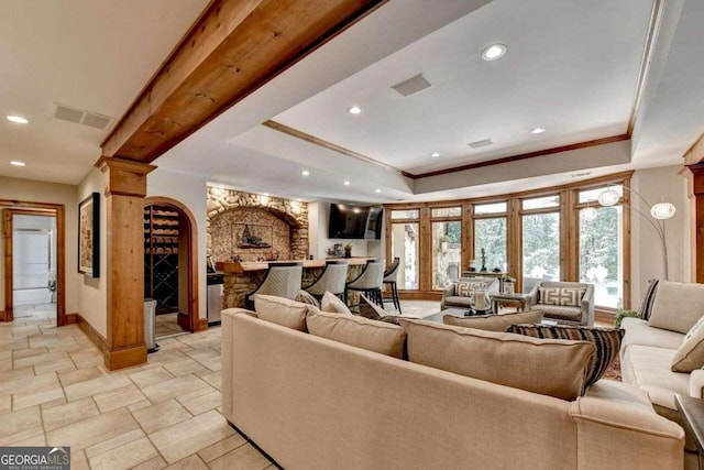 living room featuring a raised ceiling, ornate columns, and french doors