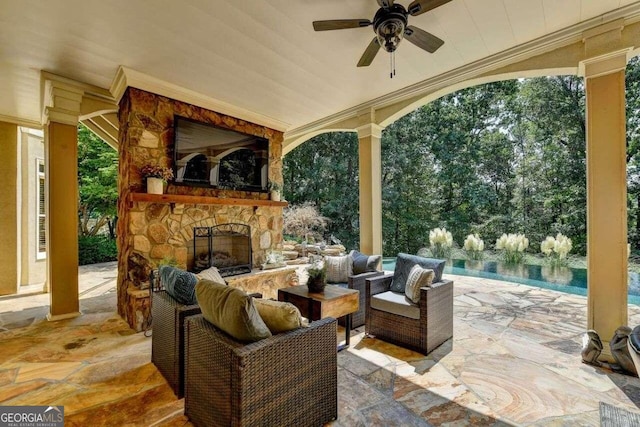 view of patio / terrace featuring an outdoor living space with a fireplace and ceiling fan