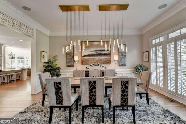 dining room featuring crown molding, a wealth of natural light, and hardwood / wood-style floors