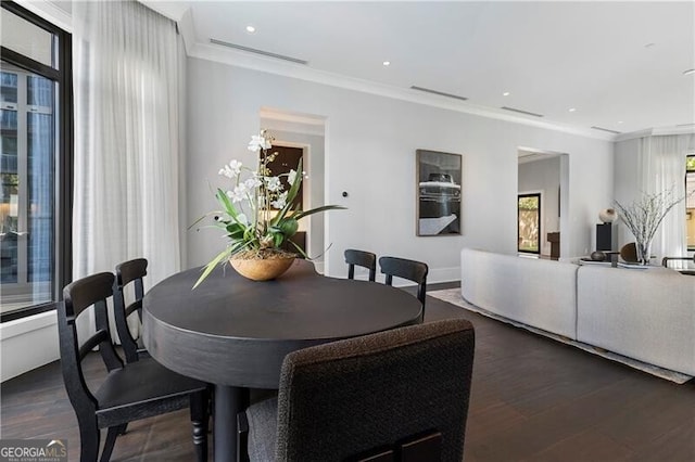 dining space featuring ornamental molding and dark hardwood / wood-style floors