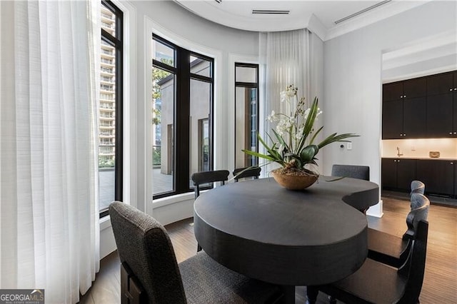 dining room with crown molding and light wood-type flooring