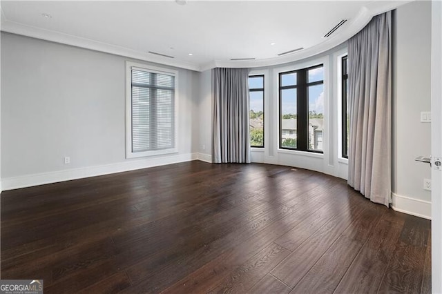 empty room with ornamental molding and dark wood-type flooring