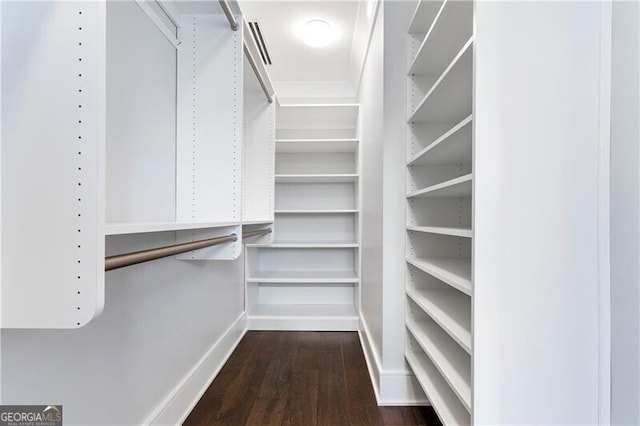 walk in closet with dark hardwood / wood-style flooring