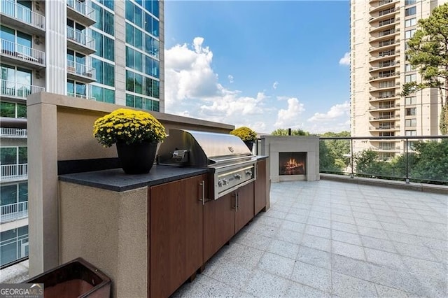 view of patio featuring a balcony, area for grilling, and exterior kitchen