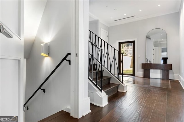 stairway featuring crown molding and hardwood / wood-style floors