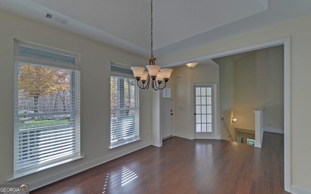 unfurnished dining area with dark hardwood / wood-style floors and a notable chandelier