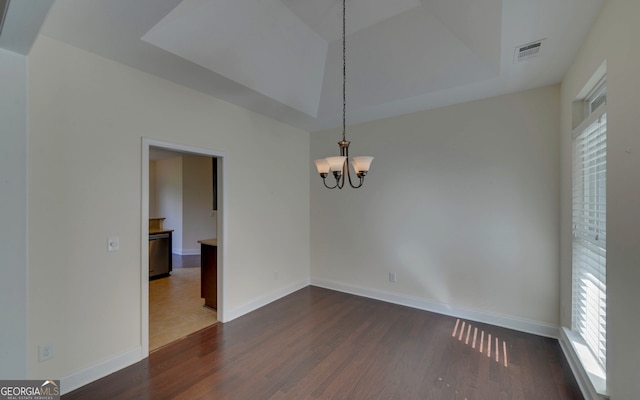 empty room with plenty of natural light, dark hardwood / wood-style flooring, and a chandelier