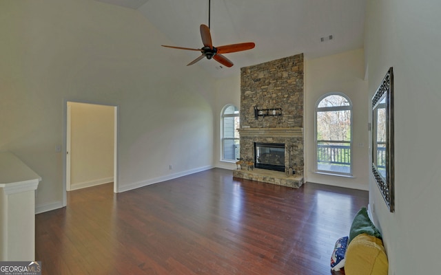 unfurnished living room featuring dark hardwood / wood-style floors, ceiling fan, a fireplace, and high vaulted ceiling