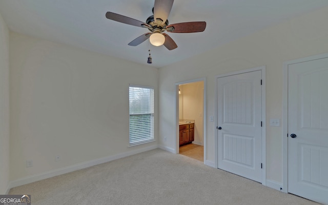 unfurnished bedroom featuring ceiling fan, light carpet, and connected bathroom