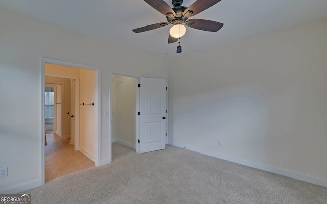 unfurnished bedroom with ceiling fan and light colored carpet