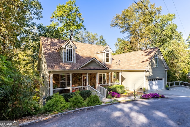 new england style home with a garage and covered porch