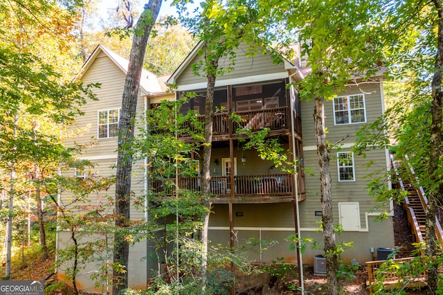 rear view of property featuring a sunroom, a balcony, and central AC unit