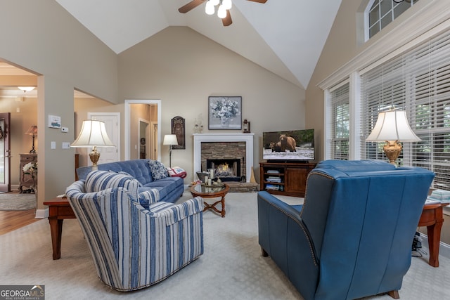 living room featuring high vaulted ceiling, a fireplace, ceiling fan, and carpet