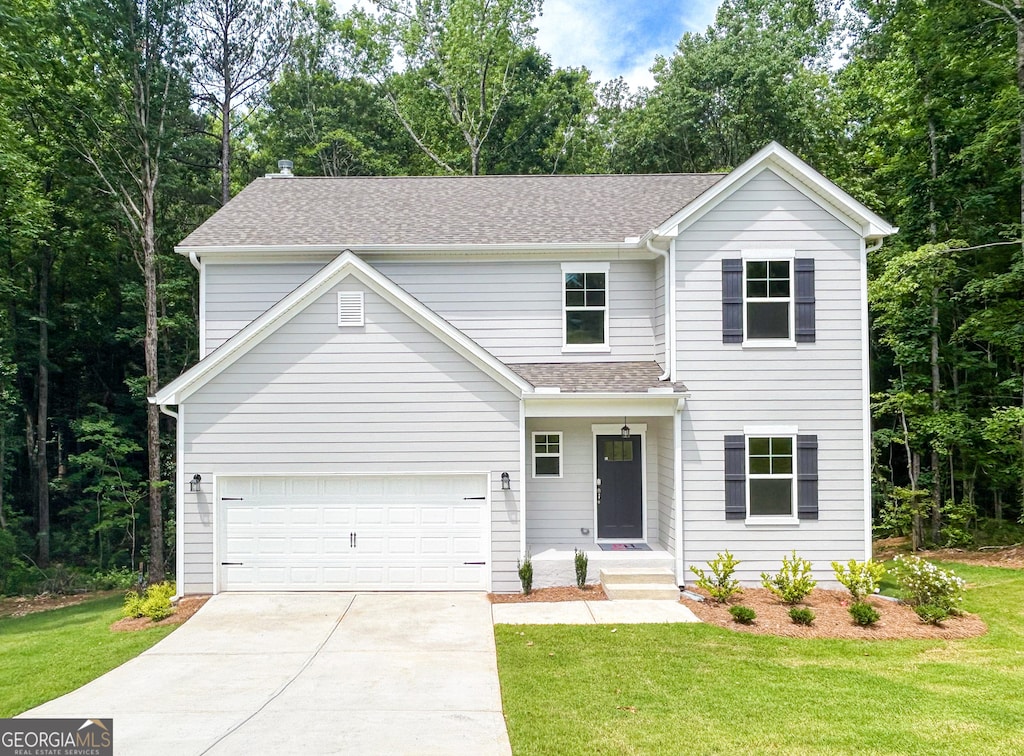 view of front of property featuring a garage and a front lawn