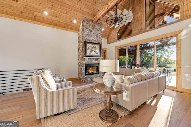 living room featuring beam ceiling, light hardwood / wood-style flooring, wooden ceiling, a fireplace, and high vaulted ceiling