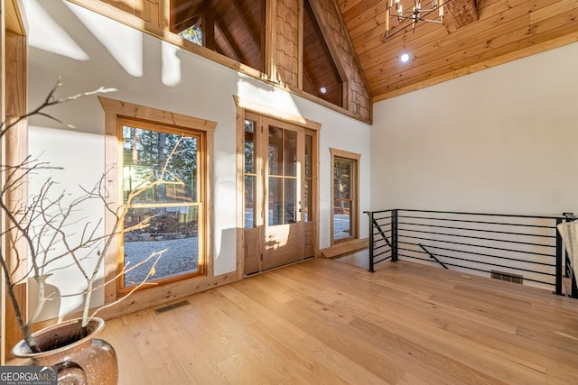 entryway featuring wood ceiling, hardwood / wood-style floors, beam ceiling, high vaulted ceiling, and an inviting chandelier