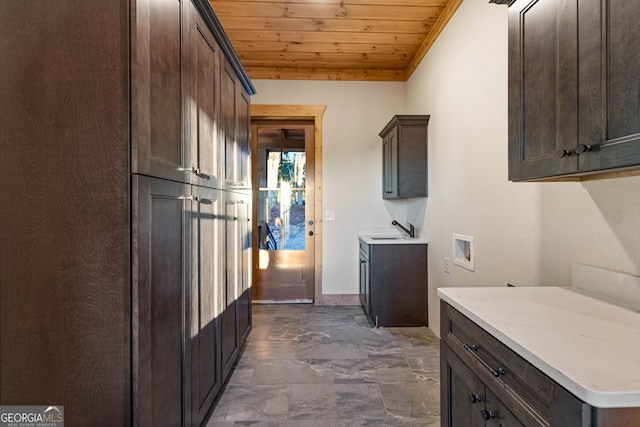 kitchen featuring dark brown cabinets, wooden ceiling, sink, and ornamental molding