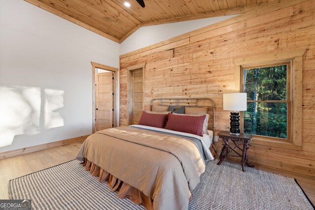 bedroom with wood ceiling, hardwood / wood-style flooring, vaulted ceiling, and wooden walls