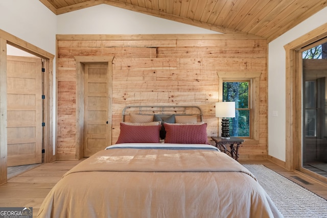 bedroom with light hardwood / wood-style floors, wood ceiling, wooden walls, and lofted ceiling