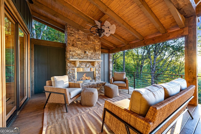 sunroom / solarium featuring an outdoor stone fireplace, lofted ceiling with beams, and wooden ceiling