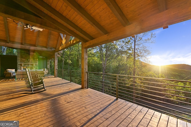 wooden terrace featuring a mountain view and ceiling fan