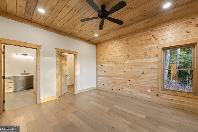 spare room with wooden ceiling, sink, ceiling fan, light wood-type flooring, and wood walls