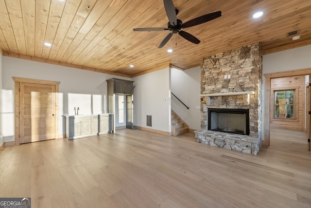 unfurnished living room with wood ceiling, a wealth of natural light, light wood-type flooring, and a fireplace