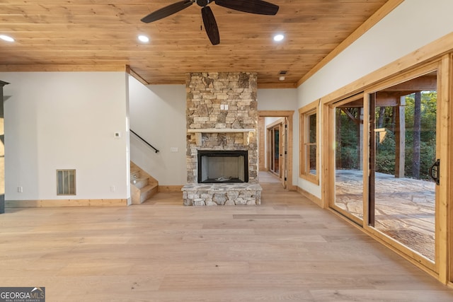 unfurnished living room with light hardwood / wood-style flooring, wood ceiling, a fireplace, and ceiling fan