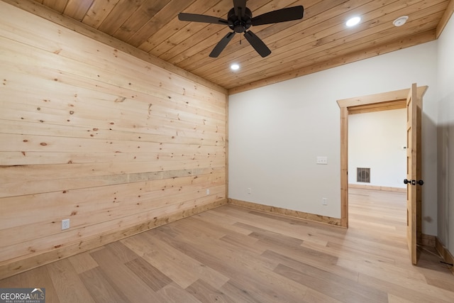 unfurnished room featuring wooden walls, wood ceiling, light wood-type flooring, and ceiling fan