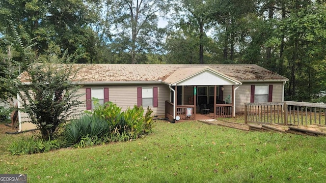 view of front of property featuring a front yard and a deck