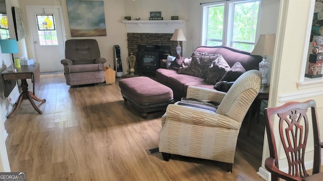 living room with hardwood / wood-style floors and a brick fireplace