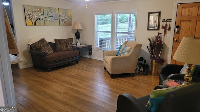 living room featuring ceiling fan, ornamental molding, and hardwood / wood-style floors