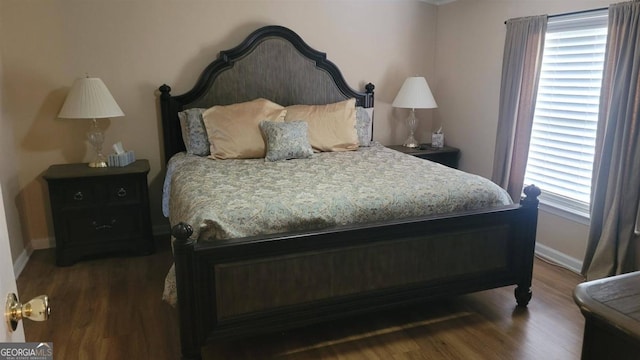 bedroom featuring dark wood-type flooring and multiple windows