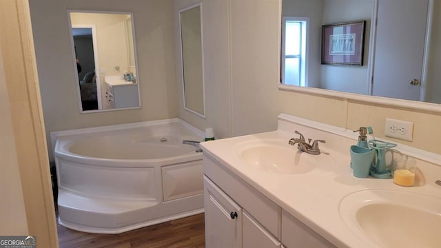 bathroom with vanity, a tub to relax in, and hardwood / wood-style flooring