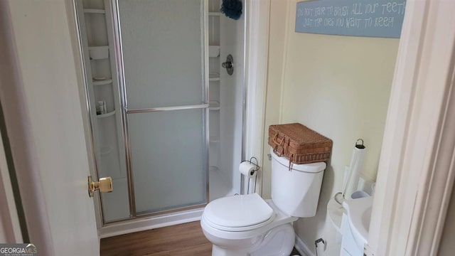 bathroom with toilet, hardwood / wood-style flooring, and an enclosed shower