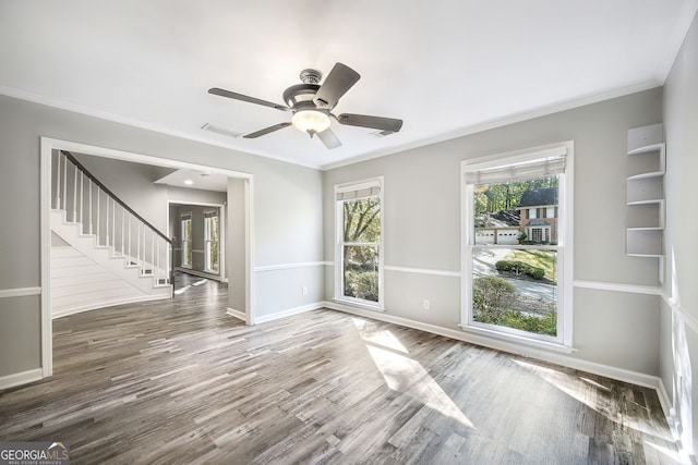 empty room featuring crown molding, dark hardwood / wood-style floors, and ceiling fan