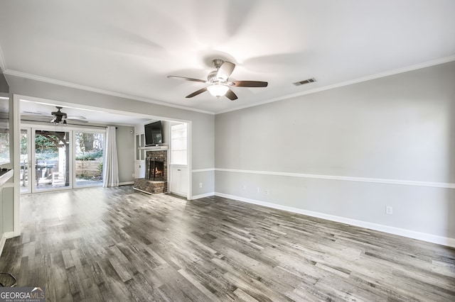 unfurnished living room featuring ornamental molding, a brick fireplace, hardwood / wood-style flooring, and ceiling fan