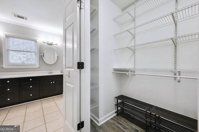 bathroom featuring vanity, ornamental molding, and tile patterned flooring