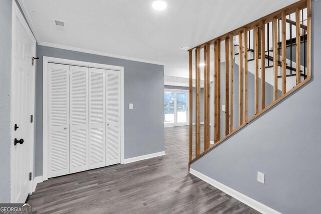 entrance foyer featuring ornamental molding and dark wood-type flooring